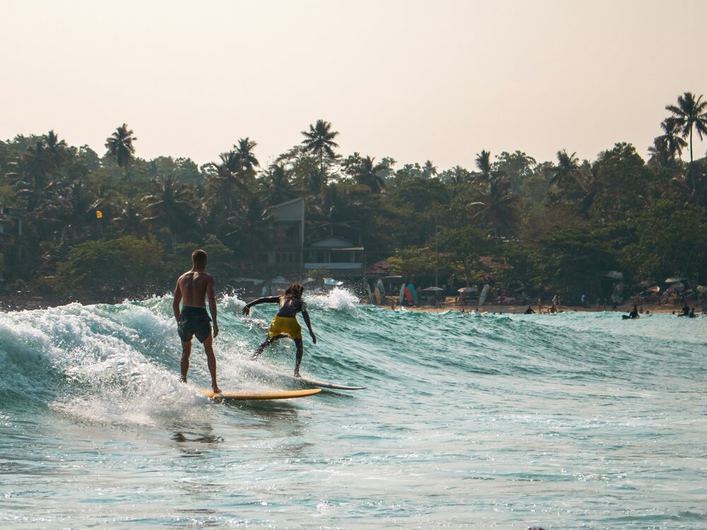 Surfers catching a wave at a Sri Lanka south coast surf break
