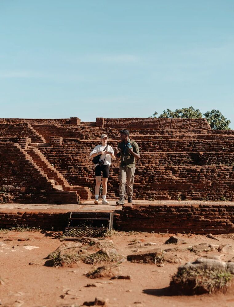 Guest and local guide exploring ancient Sri Lankan ruins