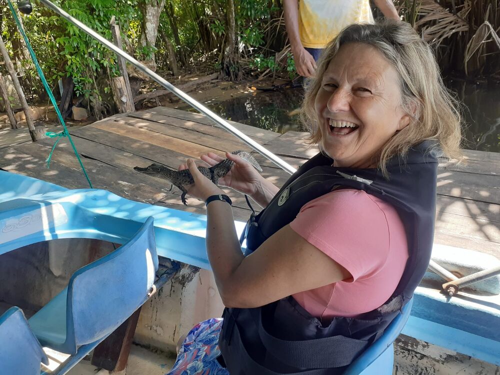 Guest holding a baby crocodile on a mangrove boat trip, Sri Lanka