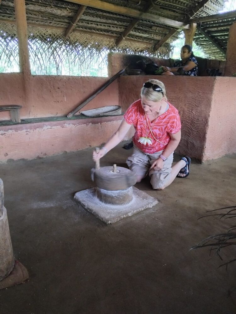 Guest using a traditional stone grinder, Sri Lankan village experience