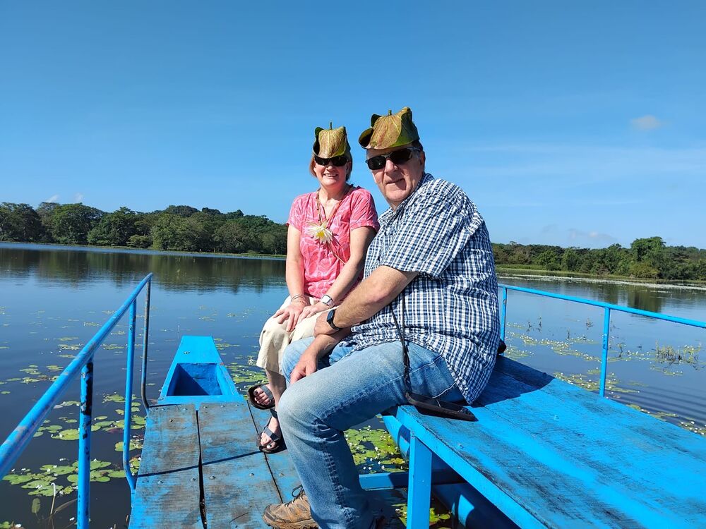 Guests wearing lotus-leaf hats on a lake boat trip in Sri Lanka
