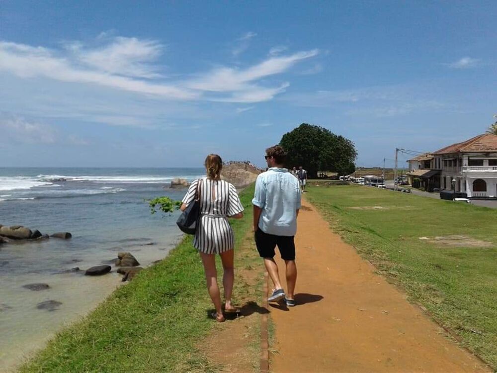 Guests walking along the Galle Fort coastal path, Sri Lanka