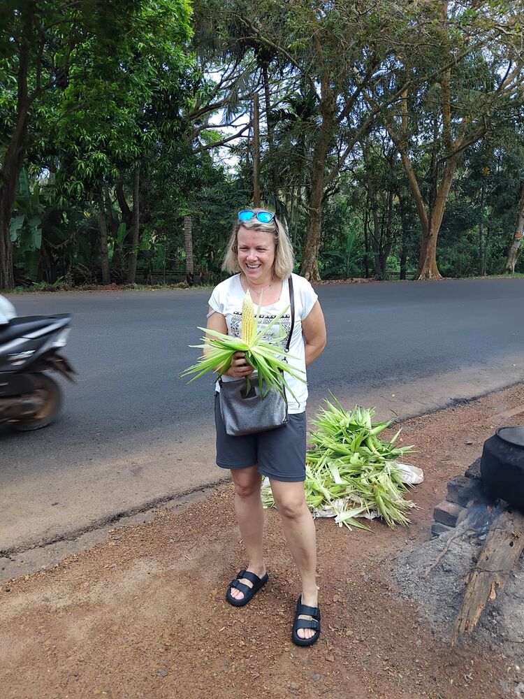 Guest holding fresh corn from a roadside stall